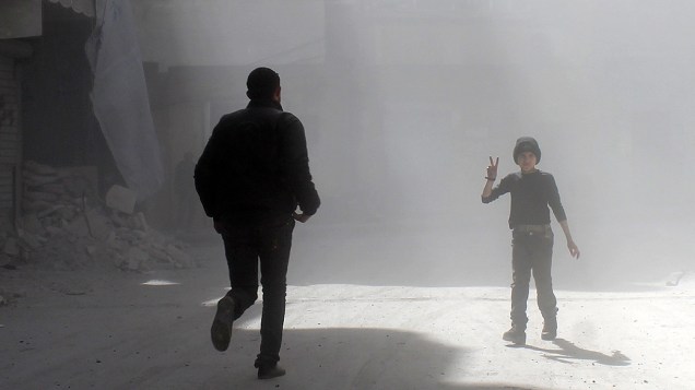 Em Aleppo, criança faz sinal para fotógrafo durante conflitos na Síria