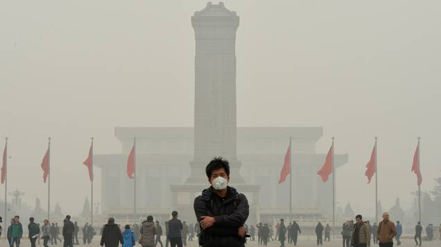 Turista é fotografado em meio à densa fumaça de poluição em que amanheceu Pequim nesta quarta-feira (26), na China