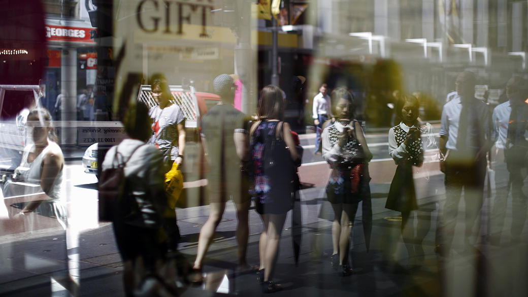 Consumidores refletidos em uma vitrine de Sydney. As vendas no varejo australiano e as exportações saltaram para níveis recordes
