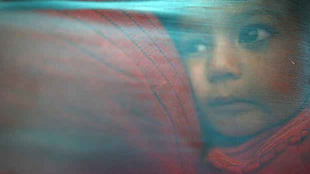 No Nepal, menino é coberto com xale enquanto aguarda atendimento médico