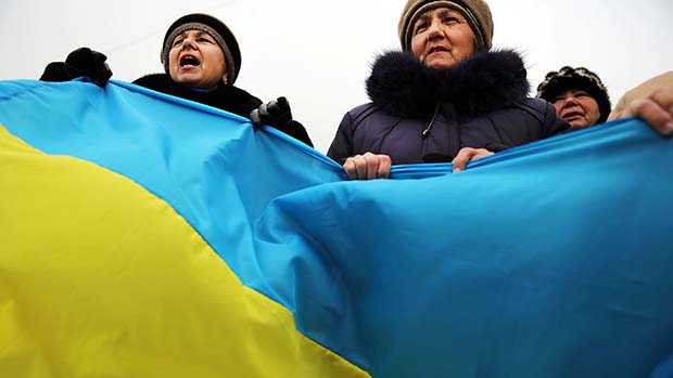 Em Simferopol, apoiadores pró-ucranianos carregaram uma grande bandeira do país em um protesto contra a integração da região de Crimeia à Rússia