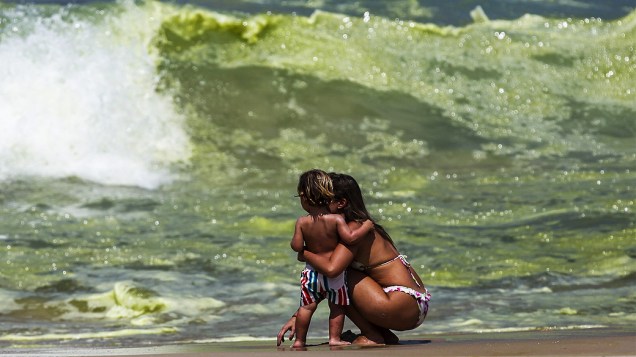 Mulher observa a coloração verde da água da praia de Ipanema, no Rio de Janeiro, nesta sexta-feira (21)<br><br> 