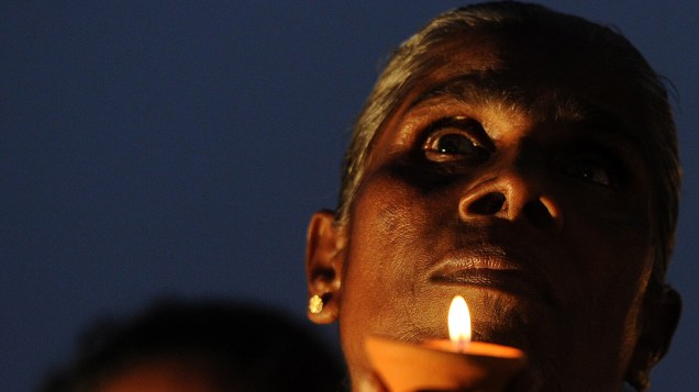 Devoto budista segura lâmpada de óleo, no Sri Lanka