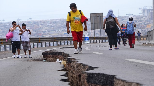 Pessoas caminharam ao longo de uma estrada rachada após um novo terremoto em Iquique, norte do Chile Pessoas caminharam ao longo de uma estrada rachada após um novo terremoto em Iquique, norte do Chile