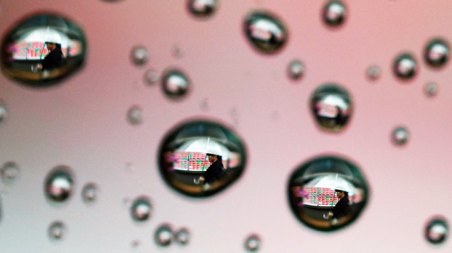 Imagem de uma mulher com guarda-chuva foi refletida em gotas de chuva na janela de um carro em Tóquio Imagem de uma mulher com guarda-chuva foi refletida em gotas de chuva na janela de um carro em Tóquio