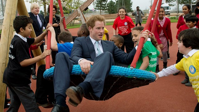 O príncipe Harry brinca com crianças em balanço durante visita ao Elizabeth Olympic Park antes de sua abertura em Stratford, no leste de Londres