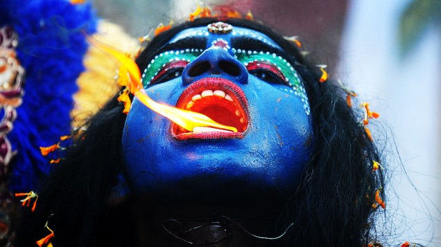 Artista indiano vestido como a deusa hindu Kali realiza performance durante festival em Allahabad