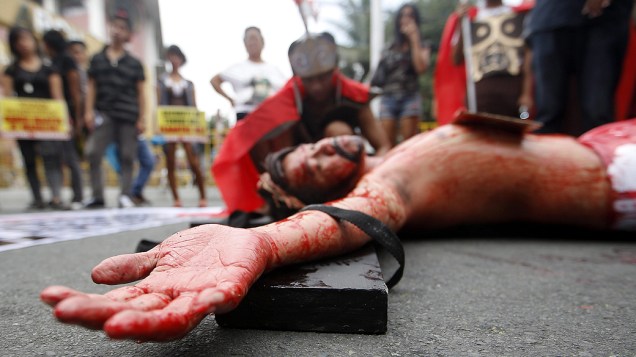 Manifestantes encenam a crucificação de Jesus durante protesto em Manila, Filipinas, nesta terça-feira (15)
