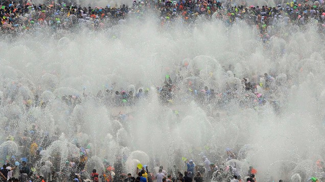 Multidão celebra o Festival anual da água, que marca o Ano Novo da minoria Dai, em Xishuangbanna, na China, nesta terça-feira (15)