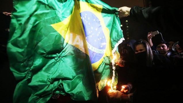 Manifestantes queimam bandeira do Brasil durante concentração no vão livre do Museu de Arte de São Paulo (Masp), na Avenida Paulista, para um ato contra a realização da Copa do Mundo no Brasil