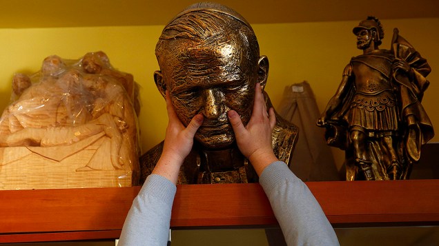 Vendedor segura um busto do falecido papa João Paulo II em uma loja na cidade de Kielce, no sul da Polônia