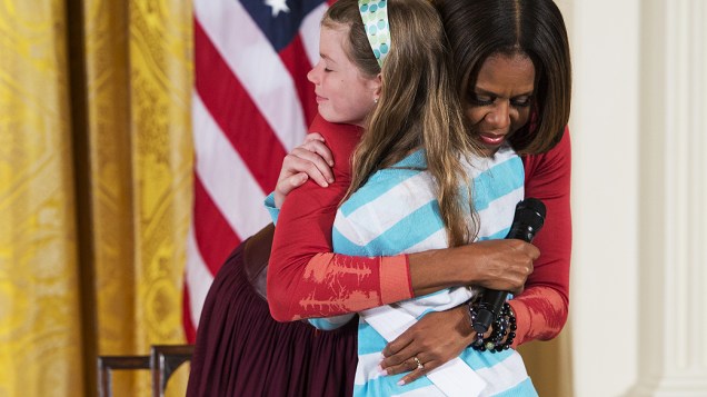 Menina entrega currículo de pai desempregado a Michelle Obama em evento na Casa Branca, nesta quinta-feira (24)