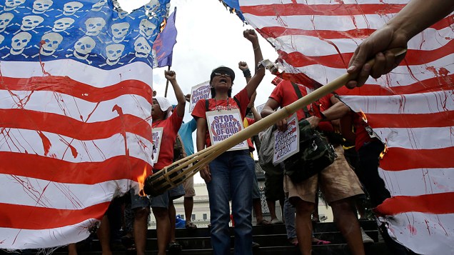 Ativistas queimam réplica gigante da bandeira dos Estados Unidos durante protesto em Manila, nas Filipinas, nesta sexta-feira (25)