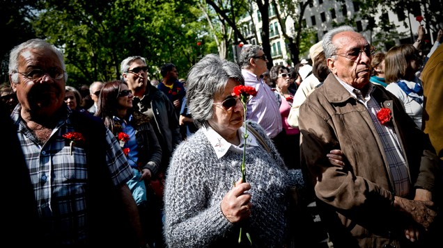 Ativistas seguram cravos vermelhos nesta sexta-feira (25), durante a marcha que celebra os 40 anos da Revolução dos Cravos, em Portugal