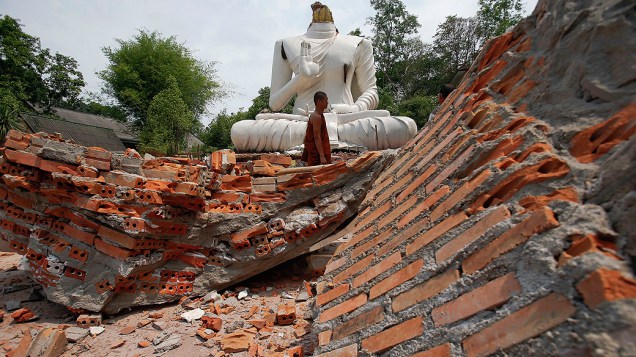 Monge passa diante de estátua de Buda destruída em Chiang Rai, após terremoto de magnitude 6 atingir o norte da Tailândia nesta terça-feira (6), horário local. Uma pessoa morreu e ao menos 23 ficaram feridas em decorrência do tremor, que ainda abalou o país vizinho Mianmar