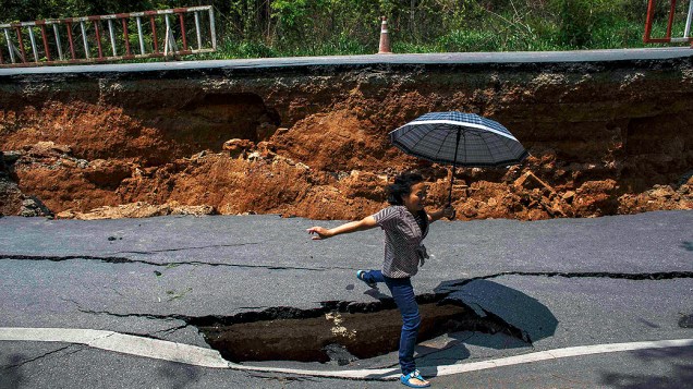 Mulher passa diante de um buraco após terremoto de magnitude 6 na Tailândia; uma pessoa morreu