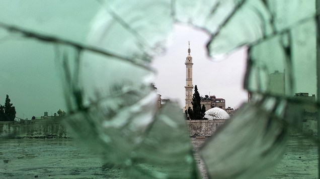 Mesquita fotografada através de um vidro quebrado na antiga cidade de Homs, na Síria. Rebeldes se retiraram do centro da cidade após três anos de combates