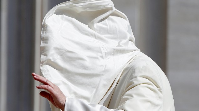 O papa Francisco ficou com o rosto coberto após encarar uma rajada de vento na chegada para a audiência semanal na Praça de São Pedro, no Vaticano