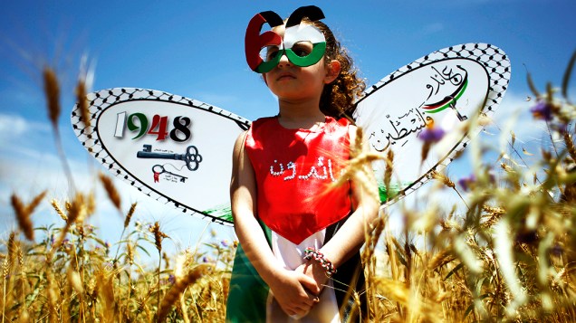 Criança palestina veste roupas em referência ao Dia de Nakba, que marca a expulsão de palestinos de suas terras por tropas israelenses em 48