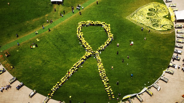 Pessoas formam uma fita amarela gigante, diante de memorial em Seul (Coreia do Sul), em homenagem às vítimas do naufrágio da balsa Sewol