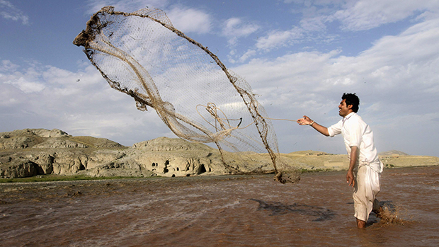 Afegão usa rede de pesca em um rio nos arredores da cidade de Jalalabad