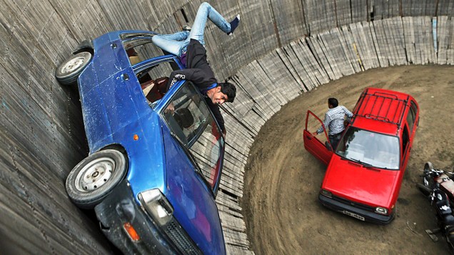 Dublê durante cena de ação em um carro no Poço da Morte, em uma exposição em Srinagar, na Índia