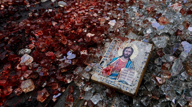 Na cidade de Donetsk, um ícone com a imagem de Jesus é fotografado próximo a cacos de vidro machados com sangue das vítimas do conflito na Ucrânia. As forças militares do país atuam contra os separatistas há meses