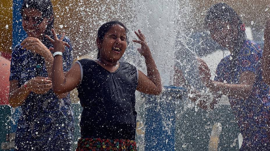 Criança brinca com água no parque de Noida, leste de Nova Deli. A Índia registrou hoje a maior temperatura da estação: 43,6 graus Celsius