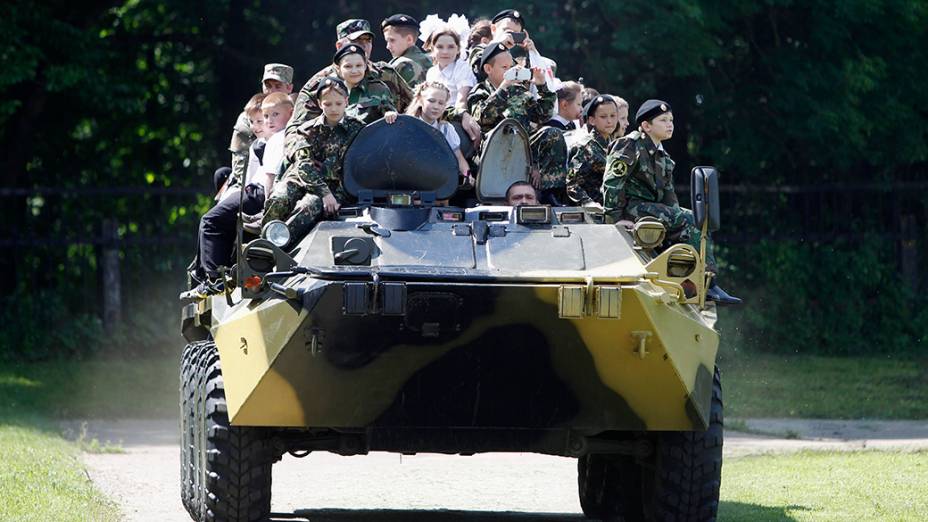 Alunos da escola General Yermolov Cadet, intituição estatal que dá aulas militares e patrióticas, passeiam em tanque de guerra para marcar o fim do ano letivo na cidade de Stavropol, sul da Rússia