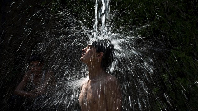 Jovem paquistanês em um chuveiro público durante dia de calor em Islamabad