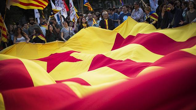 Manifestantes seguram uma enorme bandeira estelada durante protesto pela independência e a implantação da república na Catalunha após o anúncio da abdicação do rei da Espanha Juan Carlos, em Barcelona, na Espanha