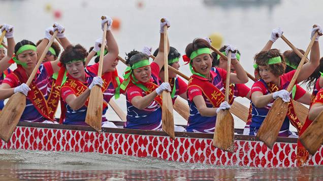 Participantes remam um barco dragão durante competição para celebrar o Festival do Barco na cidade de Yibin, sul da China