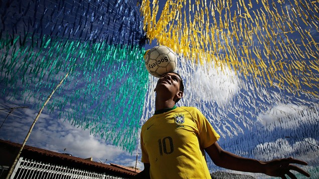 Jovem jogou bola em uma rua decorada para a Copa do Mundo, em Ceilândia, Brasília