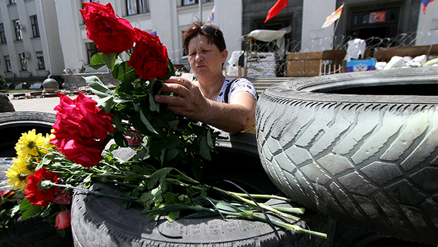 Mulher colocou flores sobre uma barricada em frente ao prédio estatal tomado por separatistas na cidade ucraniana oriental de Lugansk