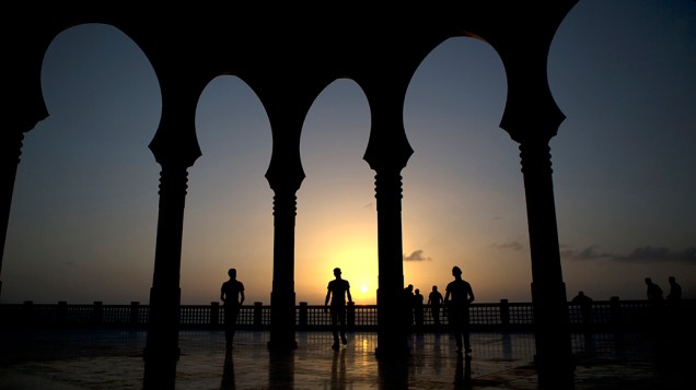 Palestinos saem de uma mesquita durante o pôr-do-sol na cidade de Gaza