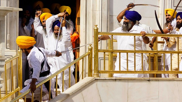 Membros de um grupo radical da religião Sikh entra em confronto com guardas do Templo Dourado, em Amritsar, na Índia