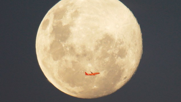 Avião comercial é fotografado em frente a lua cheia após decolar do aeroporto de Sydney, na Austrália
