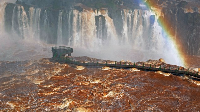 Ponte danificada nas Cataratas do Iguaçu após transbordamento do rio Paraná; No vizinho Paraguai, as inundações forçaram a evacuação de mais de cem mil pessoas em Assunção, a capital do país