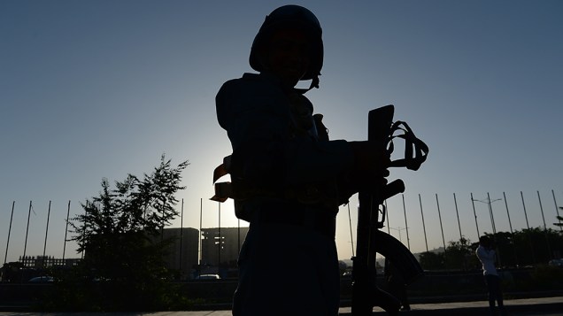 Policial afegão vigia posto de segurança em Cabul durante a segunda rodada eleitoral no país; Ameaças de ataque do Talibã comprometem a transição democrática
