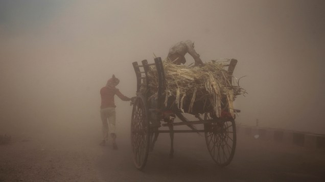 Homens caminham em meio a uma tempestade de areia na cidade de Jammu, Índia