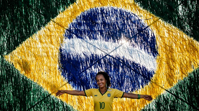 Torcedora fotografada em frente a uma bandeira do Brasil em Salvador, antes da partida contra o México 