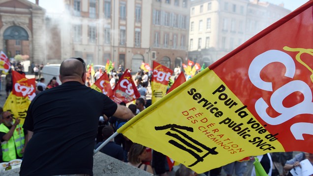 Trabalhadores da ferroviária estatal francesa, apoiados pelos sindicatos, protestam em frente a prefeitura regional contra os planos de reforma propostos pelo governo; A greve já dura uma semana