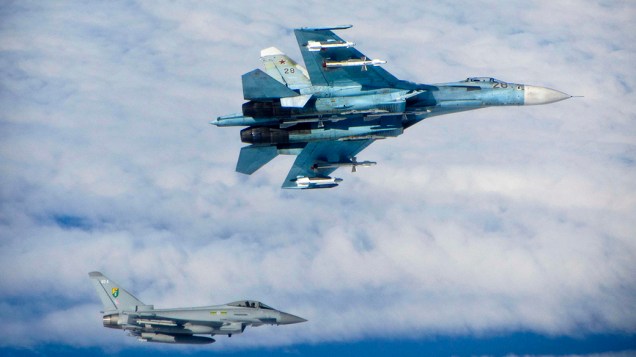 Aeronave russa é fotografada a frente de um caça da Força Aérea Britânica ao sobrevoar o espaço aéreo internacional perto dos Estados Bálticos; O Ministério de Defesa da Grã-Bretanha informou que os aviões militares que adentrarem a região sem permissão serão interceptados 