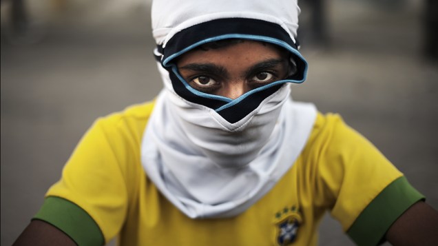 Garoto vestindo uma camisa da seleção brasileira de futebol é fotografado durante confrontos entre a polícia e manifestantes anti-governo, na cidade de Isa, no Barein
