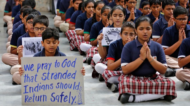 Crianças indianas oram pelos cidadãos sequestrados no Iraque, em uma escola na cidade de Ahmedabad; Segundo o Ministério das Relações Exteriores, o país teve acesso a localização de 40 de seus cidadãos seqüestrados no Iraque por supostos militantes islâmicos e acredita que eles estão sendo mantidos em cativeiro com os trabalhadores de outras nacionalidades 