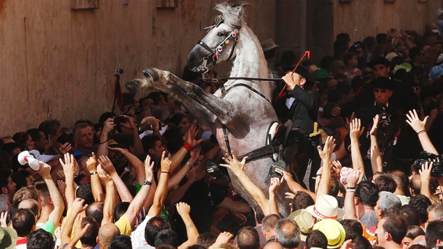 Cavaleiro se ergue em seu cavalo cercado por uma multidão durante os festejos de São João, no centro de Ciutadella, na ilha das Baleares de Menorca, na Espanha