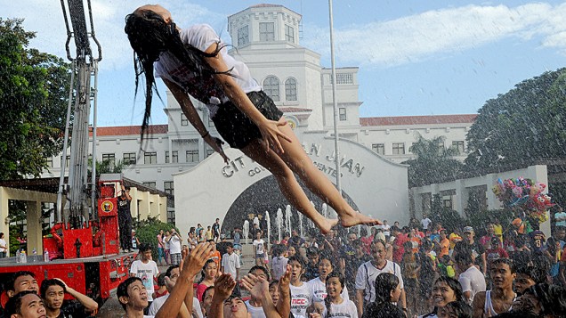 Mulher é jogada para o alto durante as comemorações do dia de São João Batista, em Manila, nas Filipinas