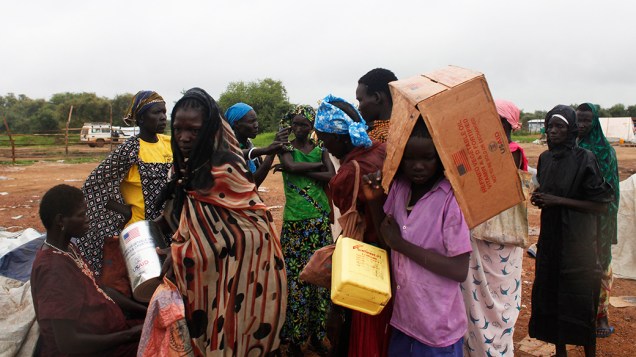 Um grupo de refugiados enfrentou a chuva durante distribuição de alimentos em Minkaman, no Sudão; Cerca de 94 mil pessoas buscaram refúgio na região após os combates começarem em estados vizinhos, de acordo com a Organização Internacional para as Migrações