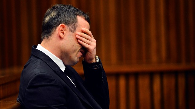 O atleta olímpico e paraolímpico, Oscar Pistorius, reage no banco dos réus durante julgamento de homicídio no Tribunal Superior do Norte Gauteng, em Pretóriana, África; Pistorius responde pelo assassinato da namorada, Reeva Steenkamp, que ocorreu ano passado