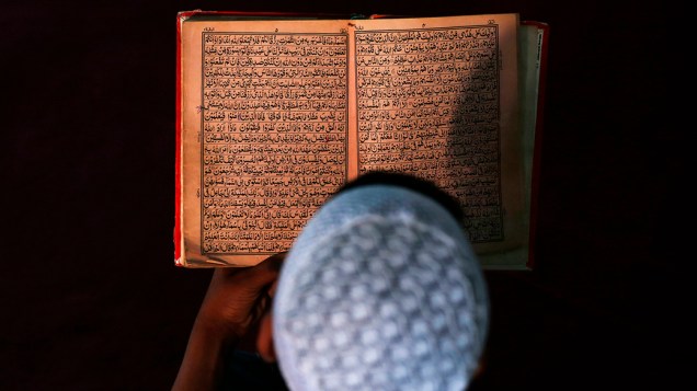 Jovem afegão lê o Alcorão em uma madrassa, escola religiosa, durante o mês sagrado muçulmano do Ramadã em Cabul